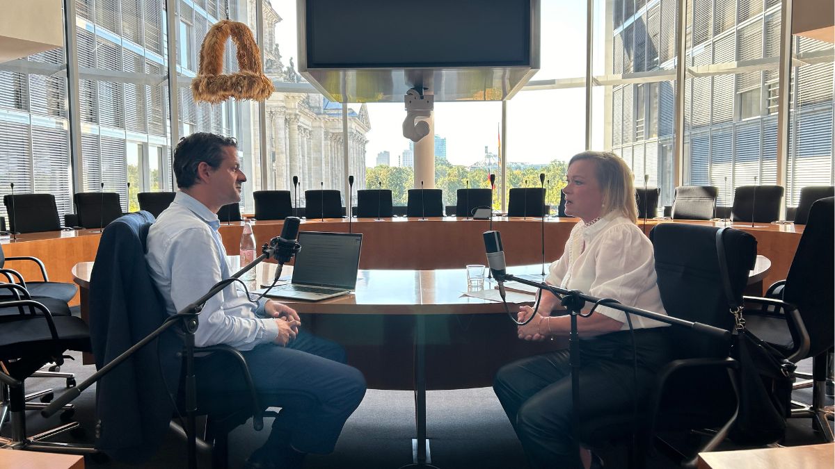 Dunja Kreiser und Arnt Baer Sitzen für die Aufnahe des Podcasts GLASKLAR an einem großen Tisch.