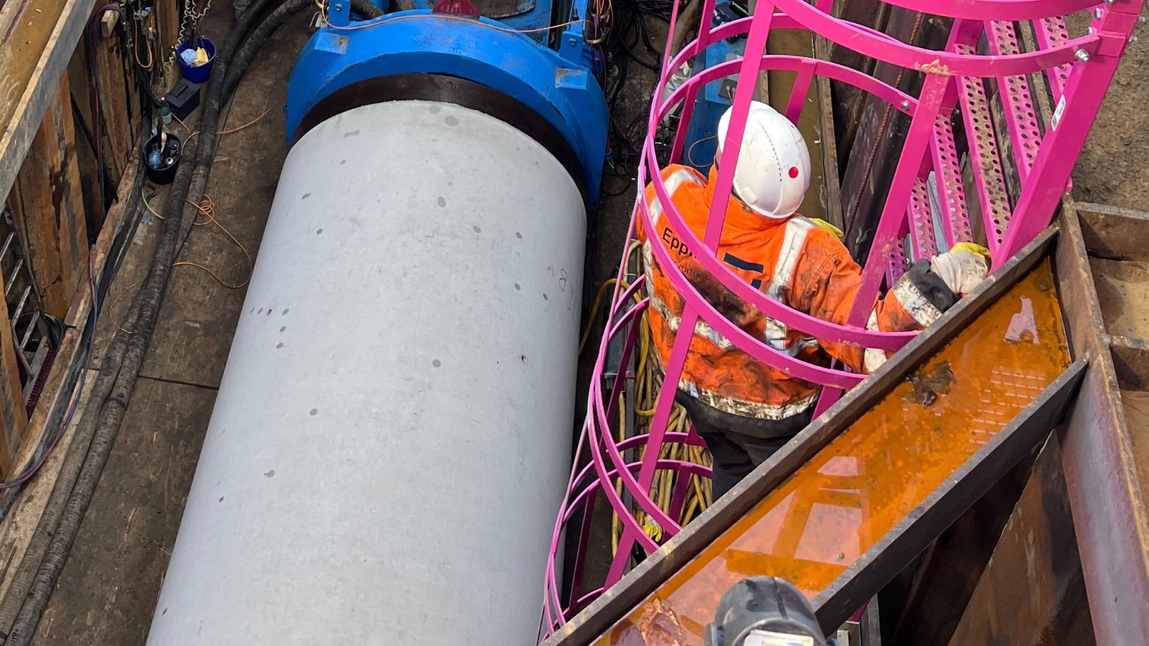 Bmennater ROhrvortrieb: Blick in die Baugrube während des Bohrpressverfahrens, bei dem ein Betonschutzrohr eingepresst wird.