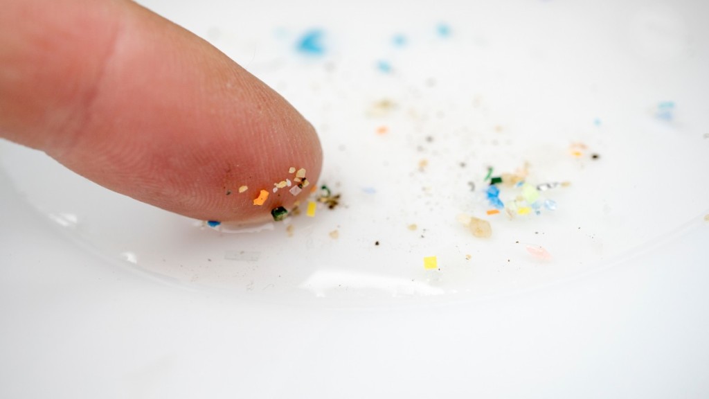 Finger mit Partikeln von Mikroplastik