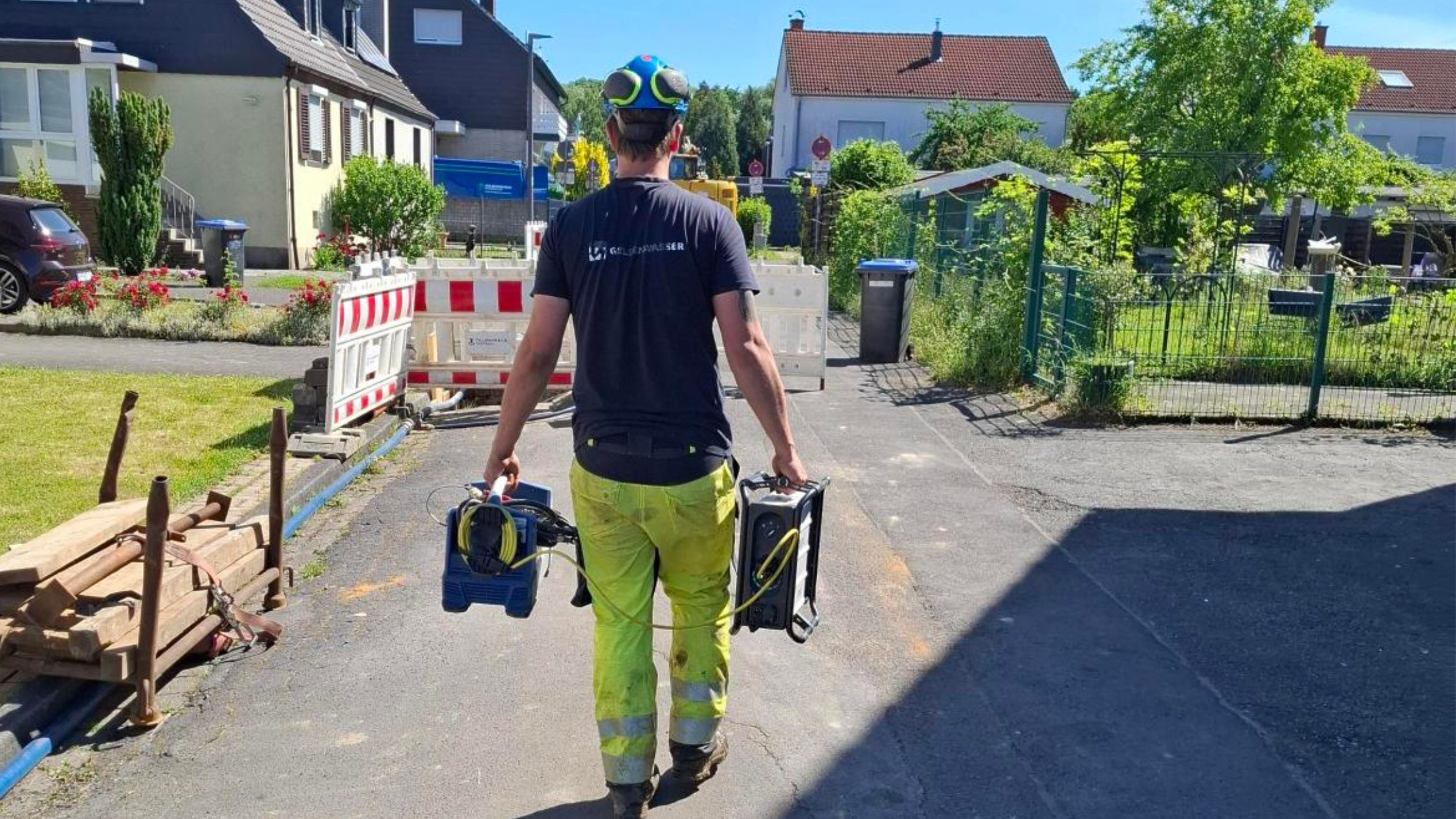 EIn Gelsenwasser-Mitarbeiter trägt einen Instagrid ONE zu einer Baustelle, dem Einsatzort.