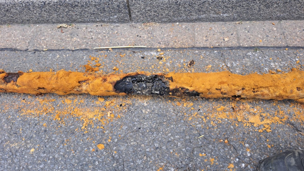 Ein defektes Stromkabel liegt auf der Straße.