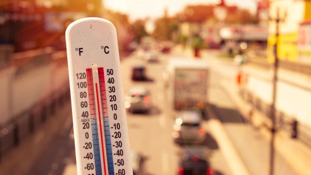 Thermometer, das Hitze anzeigt vor einer Stadtkulisse