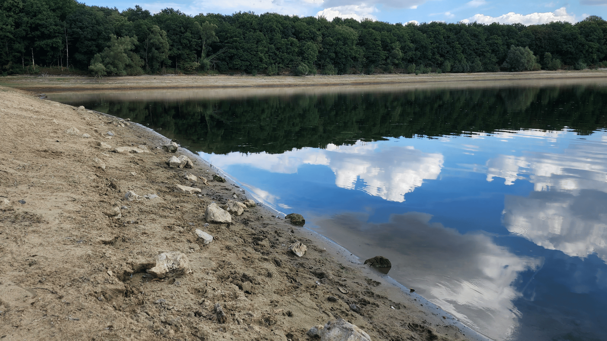 Blick auf die Talsperre Hullern im Sommer nach langer Trockenheit mit ausgeprägtem Ufer und niedrigem Wasserstand.